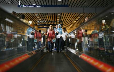 Women use the travelator at an airport in Sepang, outside Kuala Lumpur